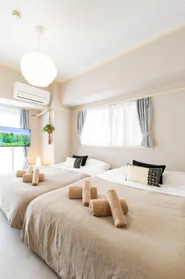 two beds in a room with white walls and windows at Beige Frame in Tokyo