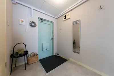 a hallway with a blue door and a table at Beige Frame in Tokyo
