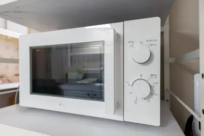 a white microwave oven sitting on a counter at Beige Frame in Tokyo