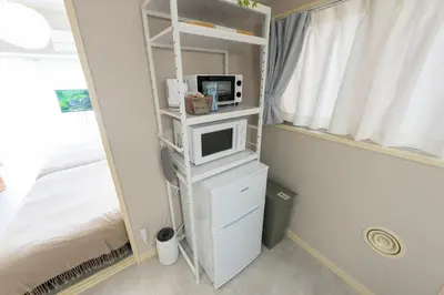 a bedroom with a bed and a tv on a shelf at Beige Frame in Tokyo
