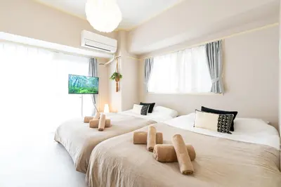 two beds with stuffed animals on them in a room at Beige Frame in Tokyo