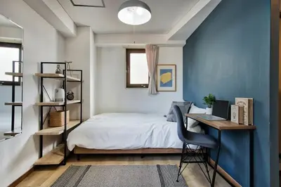 a bedroom with a bed and a desk with a laptop at CraftFlat Komagome 508, a compact studio at excellent location in Tokyo
