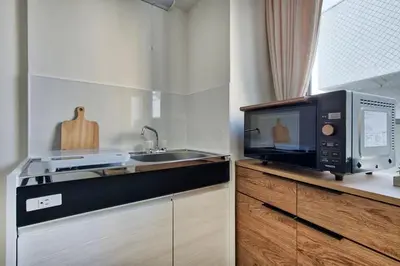 a kitchen with a microwave and a sink at CraftFlat Komagome 508, a compact studio at excellent location in Tokyo