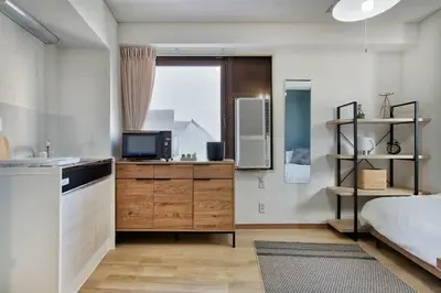 a kitchen with a bed and a television in a room at CraftFlat Komagome 508, a compact studio at excellent location in Tokyo