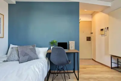 a bedroom with a bed and a desk with a computer at CraftFlat Komagome 508, a compact studio at excellent location in Tokyo
