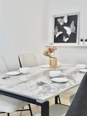 a dining room table with white plates and a vase with flowers at Ryan inn 99\u5e73\u7c73 \u6238\u5efa\u8cb8\u52071\u7d4410\u540d\u307e\u3067 JR\u6771\u5341\u6761\u99c5\u5f92\u6b693\u5206 in Tokyo