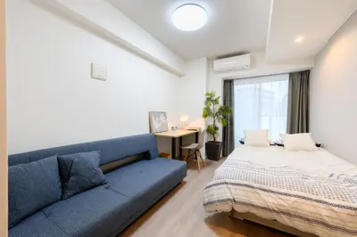 a bedroom with a blue couch and a bed at アルファサイト御茶ノ水 - Historic Ochanomizu Stay - Near Akihabara & Imperial Palace - JR & Subway Access in Tokyo