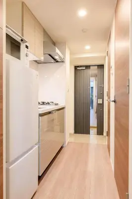 a kitchen with white appliances and wooden cabinets at アルファサイト御茶ノ水 - Historic Ochanomizu Stay - Near Akihabara & Imperial Palace - JR & Subway Access in Tokyo