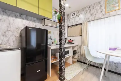 a kitchen with a black refrigerator and a table at Villa Ōyama in Tokyo