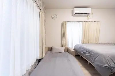 a bedroom with a bed and a window at Villa Ōyama in Tokyo