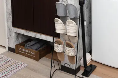 a rack of plates and shoes in a living room at Villa Ōyama in Tokyo
