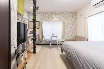 a bedroom with a bed and a living room with a table at Villa Ōyama in Tokyo