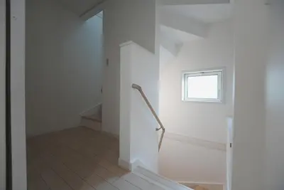a staircase in a white room with a window at Dorothy Inn Spacious 4LDK New Build 97sqm Up to 10 Guests Free Private Parking Near JR Higashi Jujo Station 3 Minute Walk in Tokyo