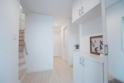 a white hallway with white cabinets and a staircase at Dorothy Inn Spacious 4LDK New Build 97sqm Up to 10 Guests Free Private Parking Near JR Higashi Jujo Station 3 Minute Walk in Tokyo