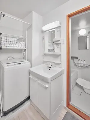 a white bathroom with a sink and a washing machine at Hagi in Tokyo