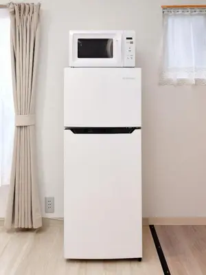 a white refrigerator with a microwave on top of it at Hagi in Tokyo