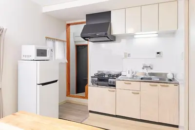 a kitchen with a white refrigerator and a microwave at Hagi in Tokyo
