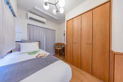a bedroom with a bed and a wooden cabinet at \u30e2\u30f3 \u30b7\u30e3\u30c8\u30fc\u4e2d\u91ce\u5e73\u548c\u306e\u68ee in Tokyo