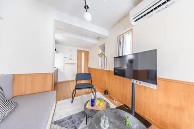 a living room with a large flat screen tv on a wall at \u30e2\u30f3 \u30b7\u30e3\u30c8\u30fc\u4e2d\u91ce\u5e73\u548c\u306e\u68ee in Tokyo