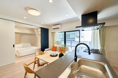 a kitchen with a sink and a living room with a bed at LIVECASA\u8535\u524d 2mins to Kuramae station in Tokyo