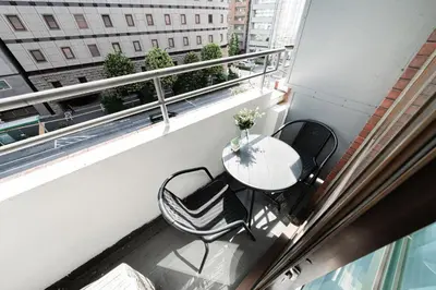 a balcony with a table and chairs on a balcony at Shinjuku Center Apart ment in Tokyo