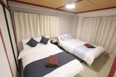 three beds in a room with curtains at HOTEL LUANA in IKEBUKURO HIGASHINAGASAKI in Tokyo