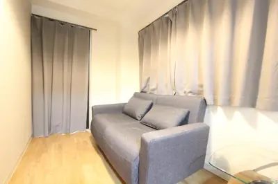 a living room with a couch in front of a window at HOTEL LUANA in IKEBUKURO HIGASHINAGASAKI in Tokyo
