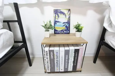 a side table with books and potted plants on it at HOTEL LUANA in IKEBUKURO HIGASHINAGASAKI in Tokyo