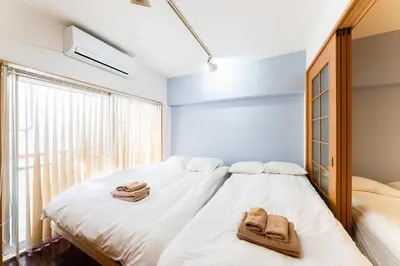 a bedroom with a large white bed with towels on it at Ohana's room Walk to Shibuya station by 8 minutes private apartment studio Max6 in Tokyo