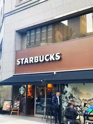 a store with a starbucks sign on the side of a building at \u6696\u71c8 DANTO inn 2F in Tokyo