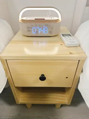 a clock on a bedside table with a box on it at \u6696\u71c8 DANTO inn 2F in Tokyo