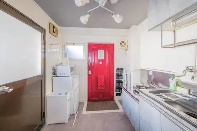 a red door in a white kitchen with a red refrigerator at Comfy Stay Tokiwadai 2minute walk from Tokiwadai Station Ikebukuro 9min Shinjuku 14min Shibuya 18min Max 4guests Many restaurants nearby hot spring Shrine nearby in Tokyo