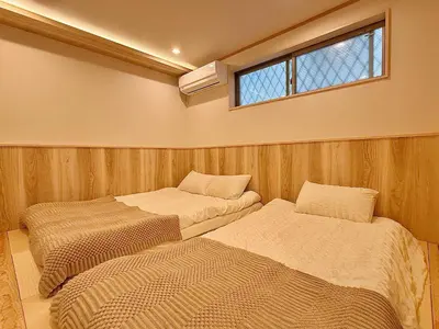 two beds in a small room with a window at \u6c60\u888b\u5168\u65b0\u72ec\u7acb3\u5c42\u522b\u5885 3\u5ba41\u53851\u6d74\u5ba42\u536b\u751f\u95f4 \u6700\u59278\u4eba max 8P \u8f66\u7ad98\u5206\u949f 8mins to ST \u94f6\u5ea7 \u65b0\u5bbf \u6d89\u8c37 \u6c60\u888b \u4e1c\u4eac\u76f4\u901a in Tokyo