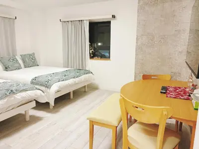 a bedroom with a table and a bed and a table and chair at \u6696\u71c8 DANTO inn 1F in Tokyo