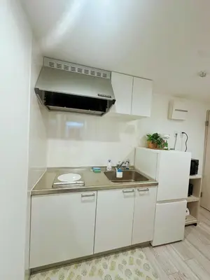 a white kitchen with a sink and a refrigerator at \u6696\u71c8 DANTO inn 1F in Tokyo