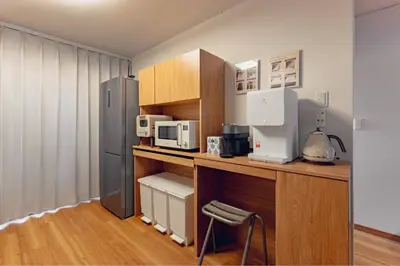a kitchen with a counter with a microwave and a refrigerator at ACOE FUYU HATSUDAI - Re-design 2BR Modish Home in Shinjuku in Tokyo