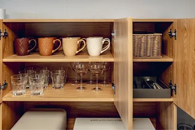 a wooden cabinet with glasses and utensils on it at ACOE FUYU HATSUDAI - Re-design 2BR Modish Home in Shinjuku in Tokyo