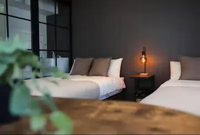 a bedroom with two beds and a table with a lamp at AkasakaStay in Tokyo