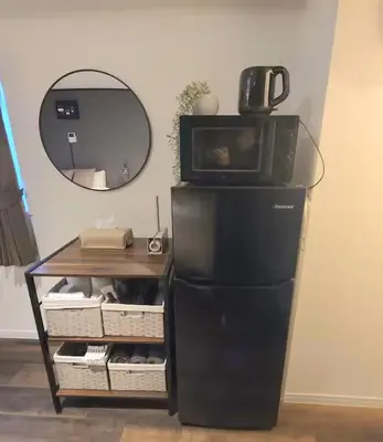 a microwave on top of a refrigerator next to a mirror at AkasakaStay in Tokyo