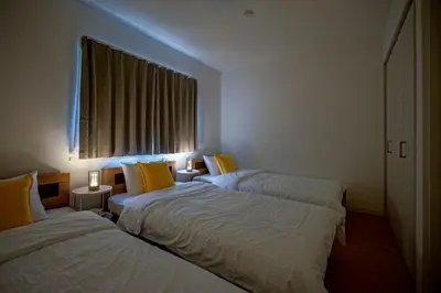 two beds with yellow pillows in a room with a window at BT House Nakano3-3min Shinjuku 15min Shibuya-Modern 2BR-Convenient access to airports in Tokyo