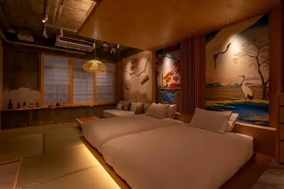 a bedroom with two beds and a painting on the wall at sumica\u6d45\u8349\u82b1\u9ce5 in Tokyo