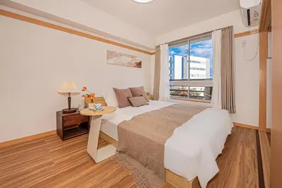 a bedroom with a large bed and a window at Mi-HOTEL SHINOTSUKA in Tokyo