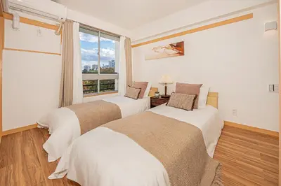 two beds in a room with a window at Mi-HOTEL SHINOTSUKA in Tokyo