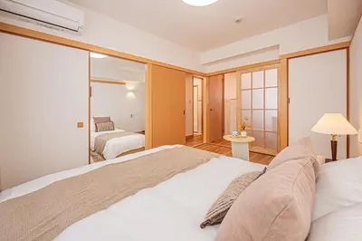 a bedroom with a large bed and a mirror at Mi-HOTEL SHINOTSUKA in Tokyo
