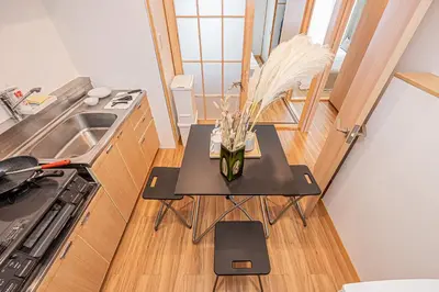 a small kitchen with a table with flowers on it at Mi-HOTEL SHINOTSUKA in Tokyo