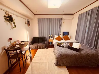a bedroom with a bed and a table and a chair at Louis House\u897f\u65b0\u5bbf in Tokyo