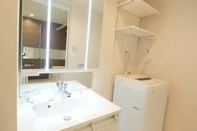 a bathroom with a sink and a mirror and a refrigerator at monthly EveryNet SHINJUKU II in Tokyo