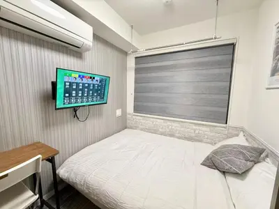 a bedroom with a bed and a tv on the wall at Shinjuku downtown b3 in Tokyo