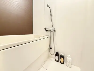 a shower in a white bathroom with a sink at Shinjuku downtown b3 in Tokyo