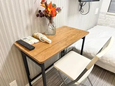 a table with a vase of flowers and a remote control at Shinjuku downtown b3 in Tokyo